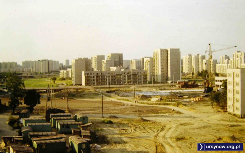 Rok 1977, baza budowlana na łące. W jednym z baraków urzęduje zapewne Józio Olk, który nada nazwę bezimiennej przestrzeni. Blok po prawej to pierwszy oddany budynek przy Wiolinowej. Zdjęcie: Andrzej Herfurt.